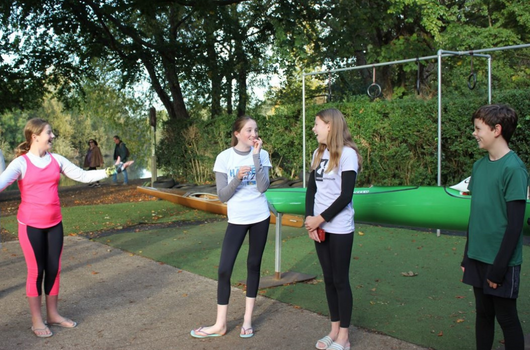 A group of 4 children at the local canoe club looking happy and in discussion